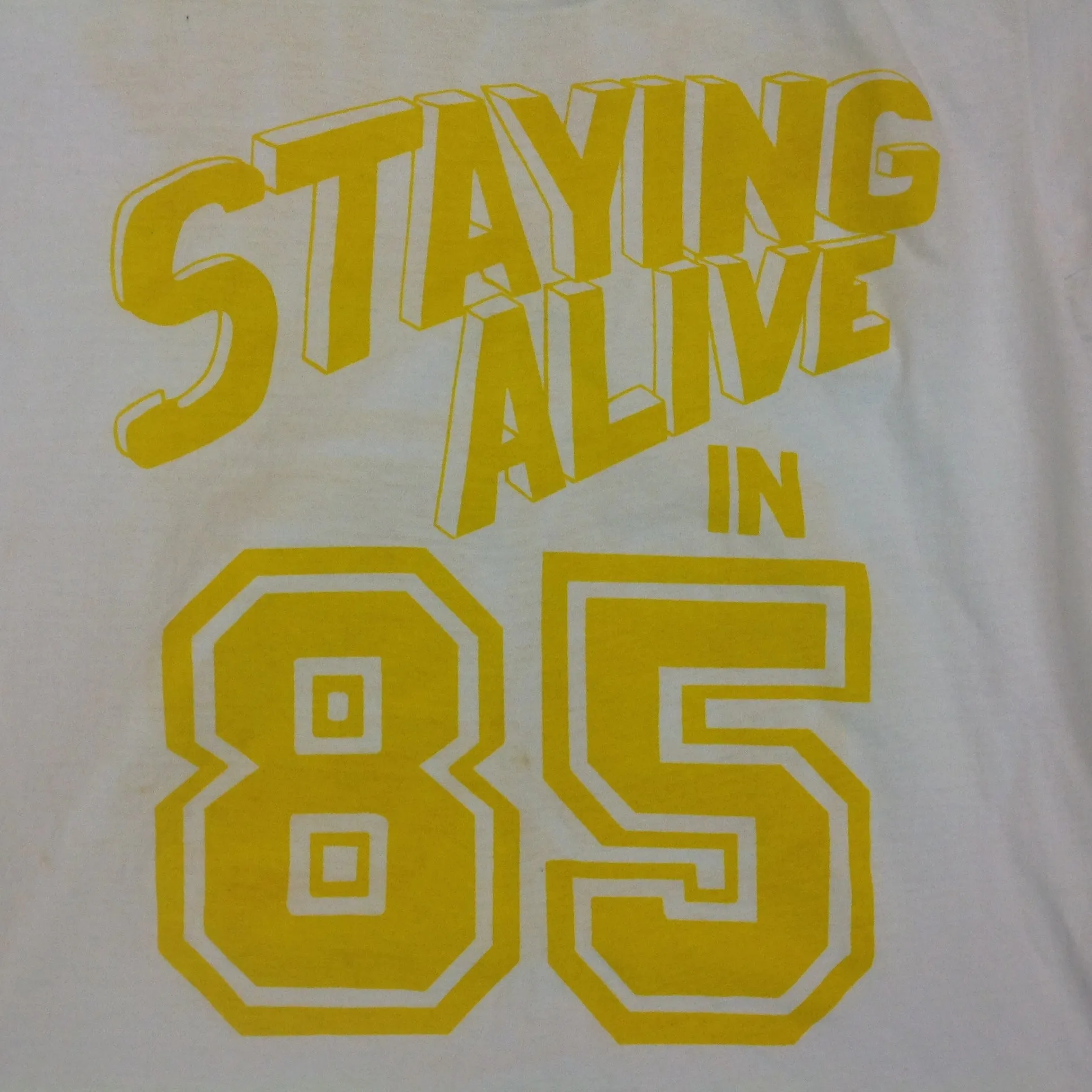 Vintage 1980's Novelty T-Shirt STAYING ALIVE IN 85 Yellow on White Katharine Hamnett