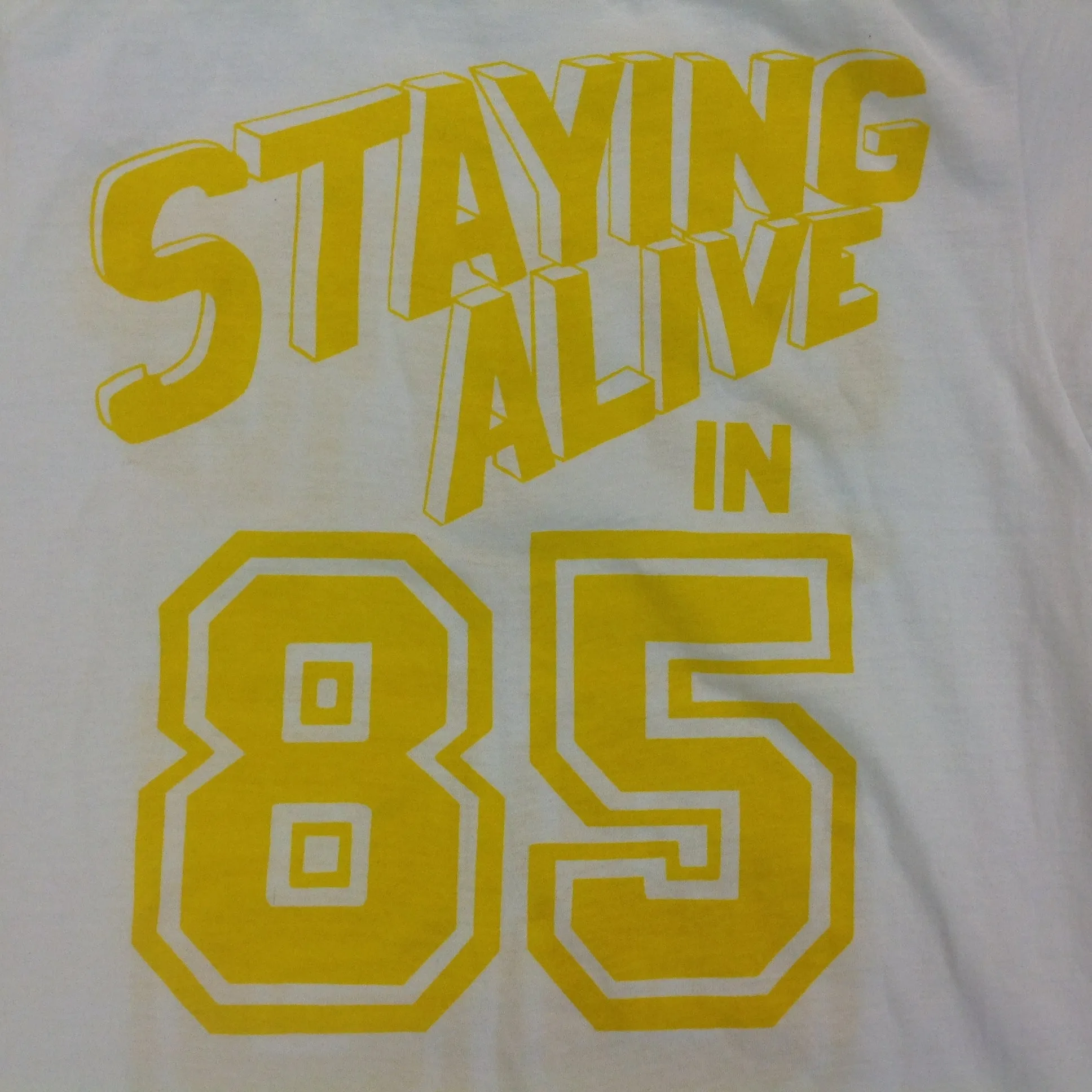 Vintage 1980's Novelty T-Shirt STAYING ALIVE IN 85 Yellow on White Katharine Hamnett